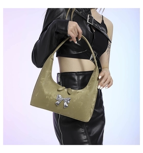 Close-up of olive green velvet Hobo bag with silver metal butterfly detail and Y2K aesthetic