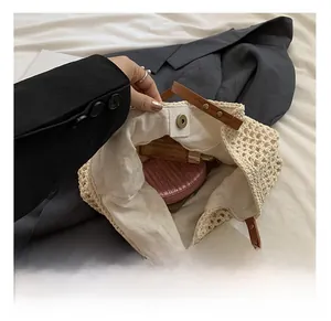 Detail view of the cream crochet shoulder bag interior with magnetic clasp and inner storage