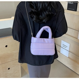 Lavender quilted PU handbag with silver bead chain strap on minimalist black outfit