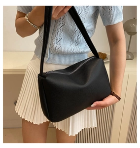 Detailed close-up of a black lychee texture PU leather shoulder bag with zipper closure