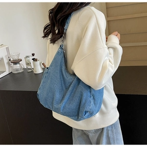 Close-up van de blauwe denim hobo tas met een halve maan vorm en vintage wassing