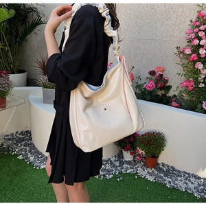 Detail of cream white PU crossbody bag with pink drawstrings and ruched shoulder strap