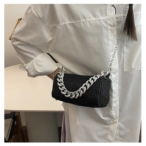 Détail d'un sac bandoulière cylindrique noir en strass avec des chaînes argentées