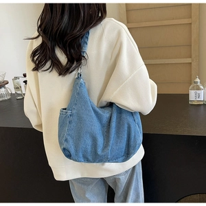 Detail van de blauwe denim hobo tas met grote capaciteit en zijdelingse steekzakken