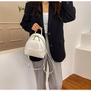 Detail view of mini cream PU leather backpack with dual zippers and sleek metallic hardware