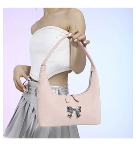 Detail of light pink PU leather underarm bag with a 3D silver metal bow accessory