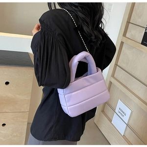 Detail of lavender quilted puff crossbody bag with silver bead chain strap and top handle
