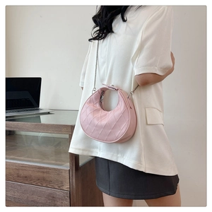 Sac demi-lune rose matelassé avec bandoulière chaîne argentée et motif à losanges