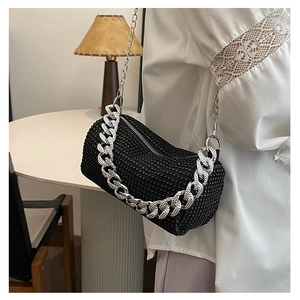 Détail du sac cylindrique noir avec strass brillants et bandoulière en chaîne argentée