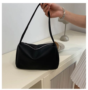 Detail of black lychee texture PU leather hobo bag with silver zipper and slim strap
