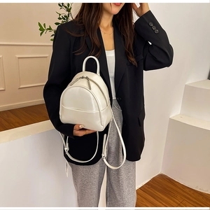 White mini PU leather backpack shown on a model with silver zippers and thin straps