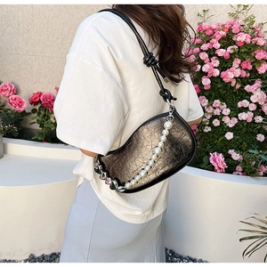 Détail du sac demi-lune vintage plissé avec texture métallique et grande chaîne de perles