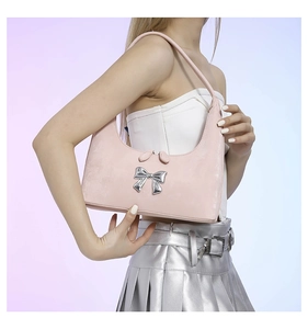 Detail of a pink PU leather Hobo shoulder bag with a silver metallic bow and Y2K aesthetic