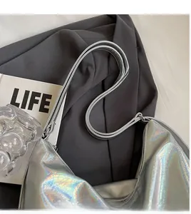 Close-up of holographic silver shoulder bag with crinkled texture and dual straps