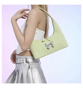 Detail of light green PU leather underarm bag featuring a silver metal bow buckle