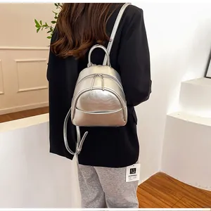 Detail view of the silver metallic mini PU backpack shown from a rear lifestyle perspective