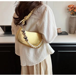 Détail du sac à bandoulière en PU doré avec breloques cœur et chaîne en perles blanches
