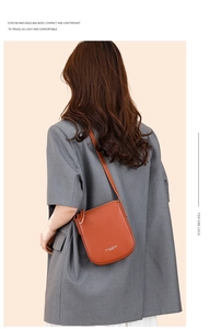 Brown lychee grain leather crossbody bag shown on a model with grey blazer