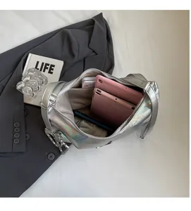 Detailed view of the spacious inner compartment of the silver laser PU handbag