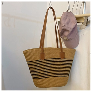 Chic woven tote bag with black stripes and brown leather handles for summer style