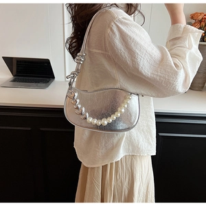 Détail d'un sac hobo argenté métallisé avec perles et breloques en cœur