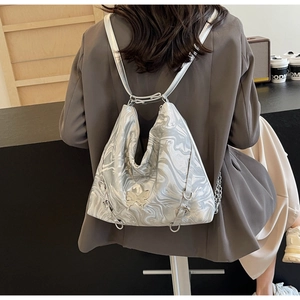 Detail of silver marble textured backpack with a metal butterfly buckle and thin straps