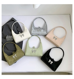 Flat lay of colorful semi-circular PU hobo bags featuring large silver metal bow details