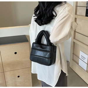 Quilted black PU leather bag with metallic ball chain worn as a stylish crossbody bag