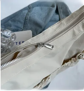 Detail eines glatten silbernen Metallreißverschlusses an einer beigen Stofftasche