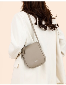 Detailed macro view of the greige lychee pattern leather texture on a crossbody bag