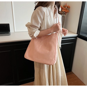 Close-up of pink PU leather tote bag with crushed texture and silver fashion logo detail