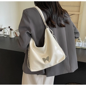 Close-up of cream white PU hobo bag with silver butterfly buckle and chain strap