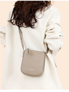 Close-up of khaki lychee grain leather crossbody bag with stylish white letter print