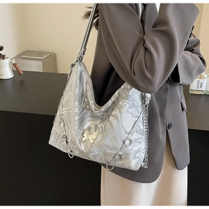 Detail of silver water ripple texture underarm bag with metallic butterfly accent