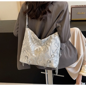 Detail of silver marble PU bag featuring butterfly clasp and chain strap on a model