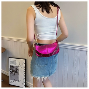 Détail du sac hobo métallisé magenta avec des rivets argentés sur la bandoulière
