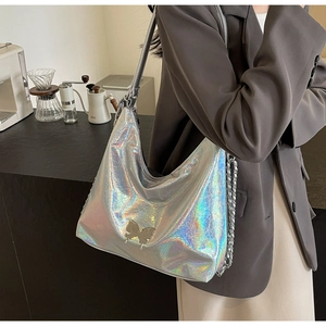 Detail of silver holographic shoulder bag with butterfly buckle and chain strap