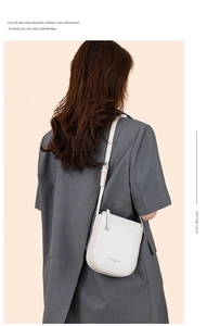Close-up of stylish white pebbled leather crossbody bag with adjustable strap on model