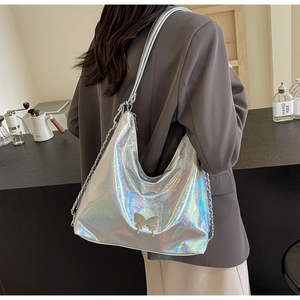Detail of silver holographic shoulder bag with metal butterfly and chain strap