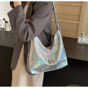 Detail of laser silver PU leather bag featuring metallic butterfly buckle and chain strap