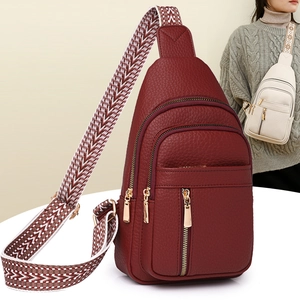 Detail view of red pebble texture crossbody bag with multi-layer zippers and woven strap