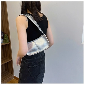 Gros plan du sac porté épaule argenté brillant avec rivets punk et finition miroir