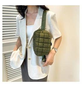 Close-up of olive green quilted puffer crossbody bag with adjustable wide nylon shoulder strap