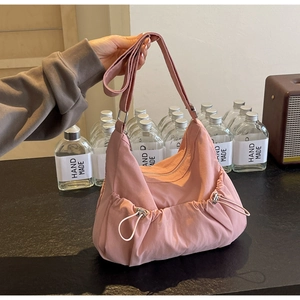 Detail der rosa Hobo-Tasche mit verstellbarem Riemen und seitlicher Kordelzugtasche