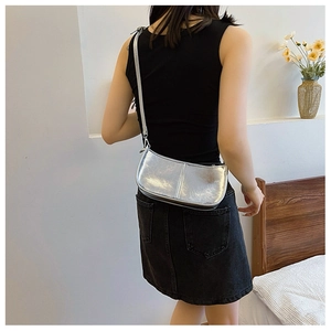 Détail du sac croissant argenté avec bandoulière réglable et texture rétro