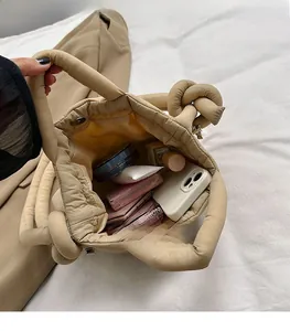 Spacious interior of khaki quilted puffer bag filled with daily makeup and essentials