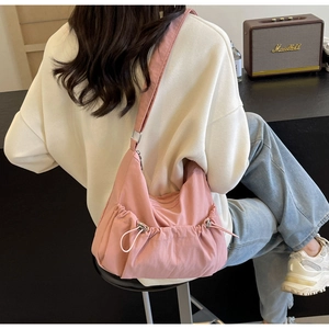 Rosafarbene Nylon-Umhängetasche mit Kordelzug-Detail und breitem Gurt am Modell
