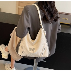 Detail of off-white PU shoulder bag with marble pattern, metal butterfly, and chain strap