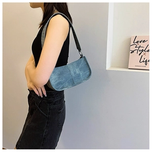 Détail du sac en jean bleu vintage avec clous métalliques et coutures verticales