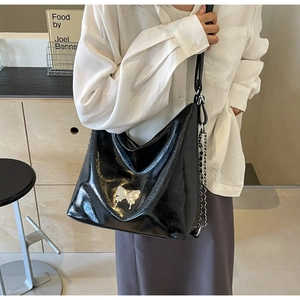 Close-up of black PU leather shoulder bag featuring silver butterfly and metal chain strap